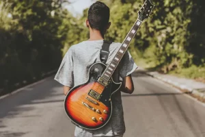 Hoe lang het duurt om gitaar te leren bij de gitaarplaats, jongen op weg met gitaar