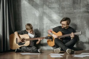 Gitaarles Utrecht kind en docent spelen gitaar