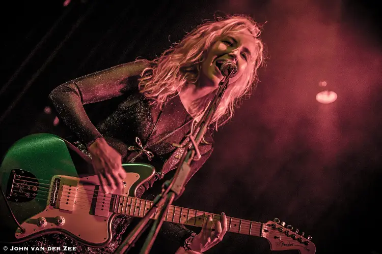 gitaar docent renske speelt gitaar op podium